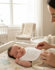 Stork And Baby white toweling dribble bib with ABC embroidery for infants, soft and absorbent for drool and spills.