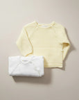 Stork And Baby yellow and white knit cardigans for infants. Soft, comfortable, and perfect for layering.