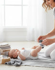 Stork And Baby 3 pack infant socks with star pattern, soft cotton blend, for 0-6 months. A mother puts socks on a baby.