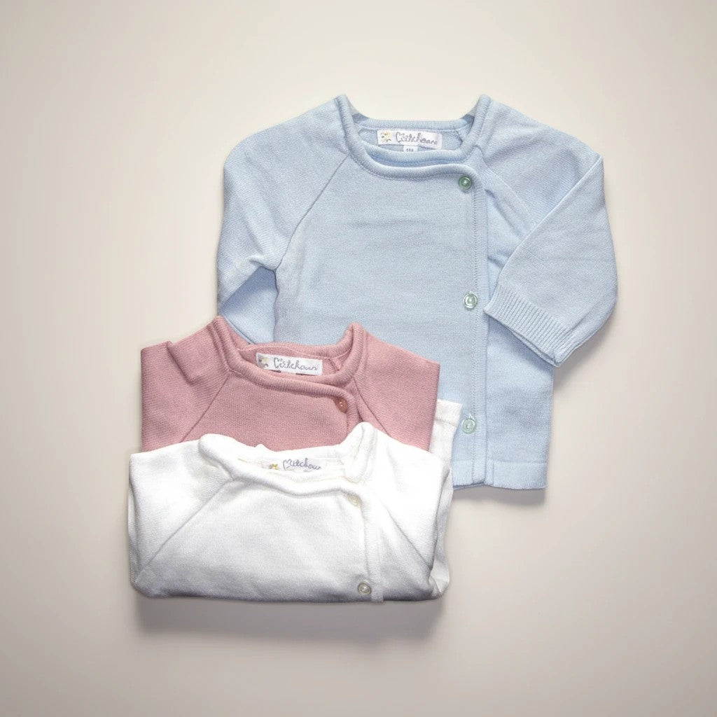 Stork And Baby assorted pastel baby cardigans in light blue, pink, and white. Soft knit, button front, perfect for layering.