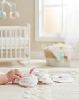 Stork And Baby white newborn mittens with pink trim and daisy print, soft mink-inspired fabric.