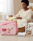 Mothers Choice Butterfly Daypack Pink diaper bag with front butterfly embroidery, plaid pattern, and adjustable strap. Stork And Baby.
