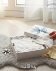 Mothers Choice White Preemie 3 Piece Set, including a wrap bodysuit, hat, and booties, presented in a gift box.