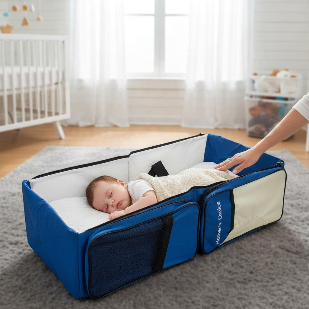 Stork And Baby Mothers Choice 3-in-1 travel bed and diaper bag in blue and beige with a sleeping baby inside