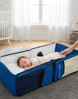 Stork And Baby Mothers Choice 3-in-1 travel bed and diaper bag in blue and beige with a sleeping baby inside