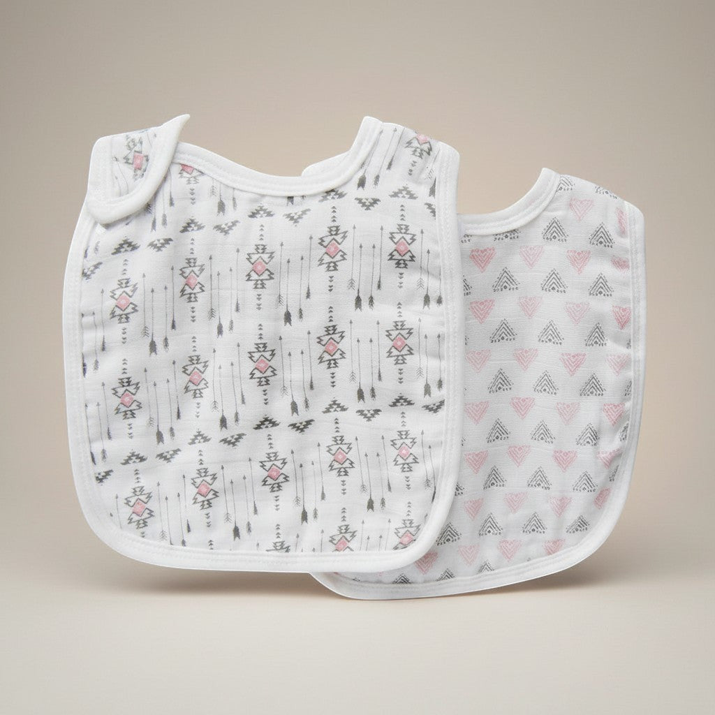 Stork And Baby 2 pack white muslin bibs with grey and pink arrows and geometric patterns.