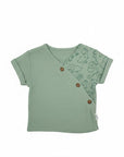 Stork And Baby 2 piece muslin set in sage green with a dinosaur print on the sleeve and wooden buttons.