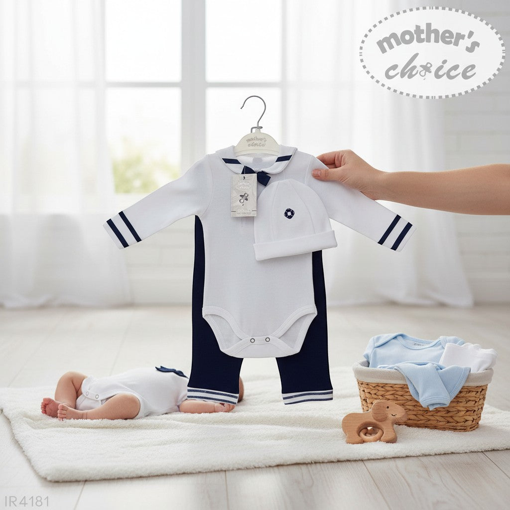 Stork And Baby white long-sleeve romper with navy sailor collar and trim, navy pants, and matching hat. A baby lies on a rug.