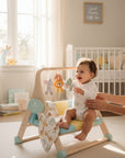Stork And Baby navy walking trainer with a happy baby sitting and playing with hanging toys. Supports early steps.