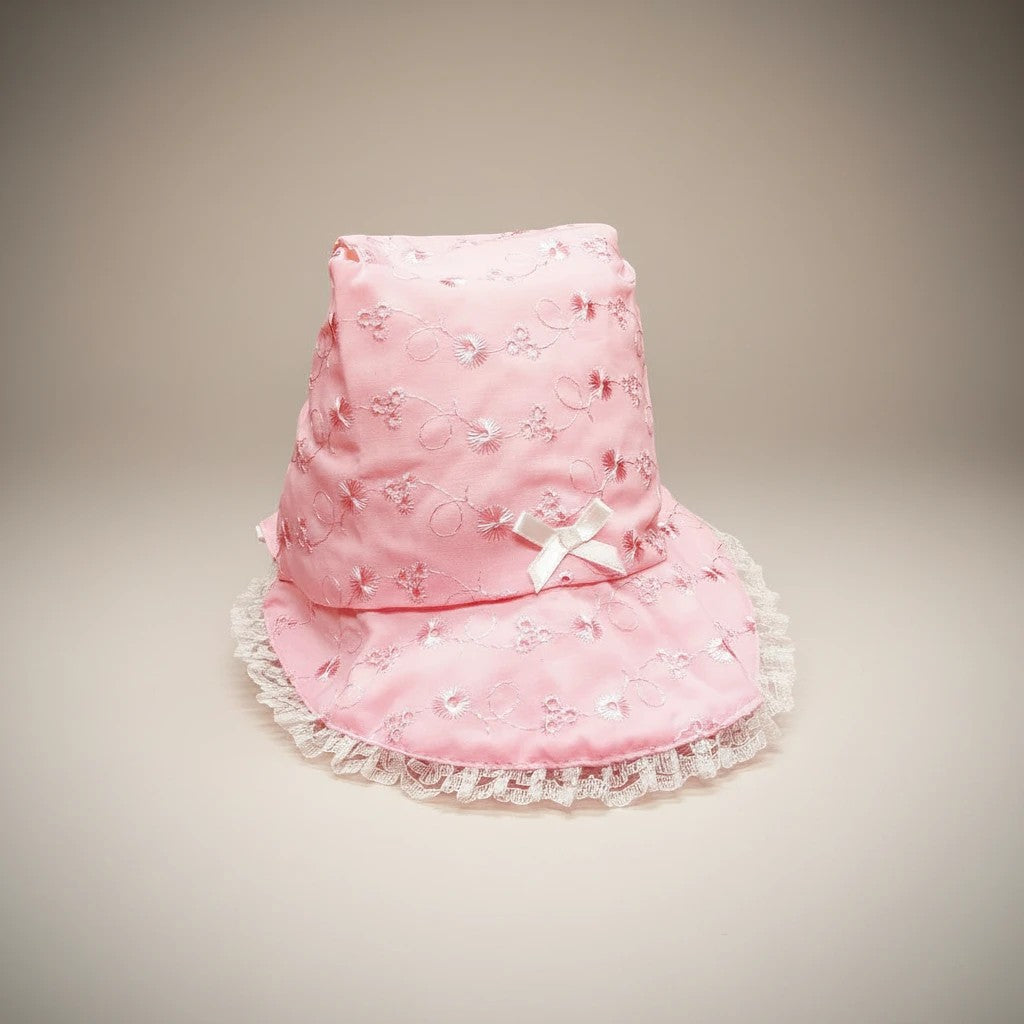 Stork And Baby pink infants anglaise hat with white lace trim and a small bow detail.
