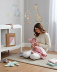 Stork And Baby pink bamboo hooded towel with heart pattern, held by a woman with a newborn baby.