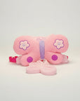 Stork And Baby pink plush butterfly harness with purple accents and flower details. Includes a detachable butterfly accessory.