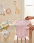 Stork And Baby pink short sleeve infant bodyvest made of soft cotton, perfect for newborns.