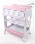 Stork And Baby pink baby bath caddy with white star pattern, storage compartments, and integrated drainage hose.
