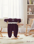 Stork and Baby plum velour baby grower with floral embroidery and white trim. Footed design.