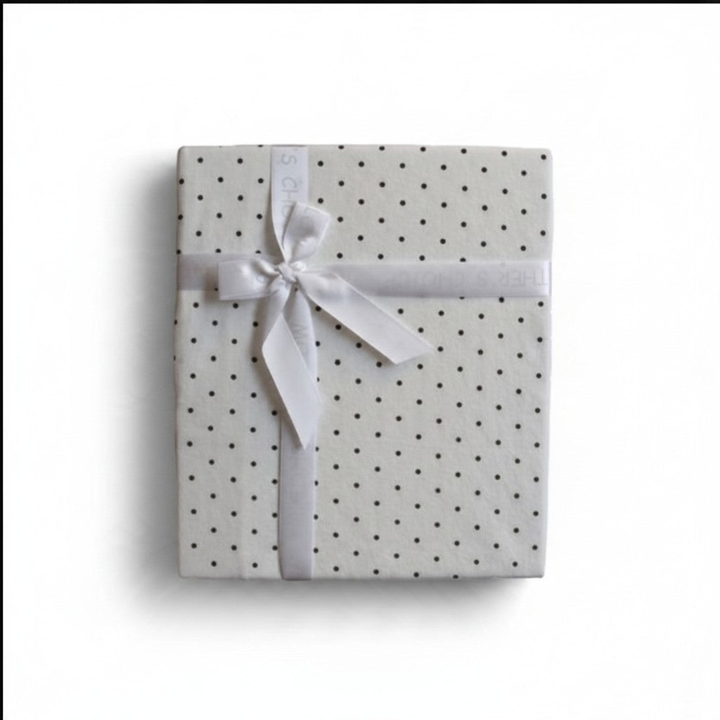 Stork And Baby Mothers Choice white cotton jersey baby wrap with black polka dots, tied with a white ribbon gift bow.