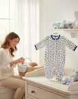 Stork And Baby white quilted grower with blue and grey leaf print, navy trim, and zipper closure.