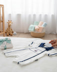 Stork And Baby white short-sleeve baby romper with navy sailor collar and trim, featuring a sailboat embroidery.