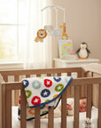 Stork And Baby white coral fleece receiver blanket with colorful stars pattern and blue trim. Newborn baby sleeping in crib.