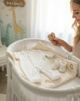 Stork And Baby white 3-6 month baby growsuit with silver embroidery, booties, and lion print mat.