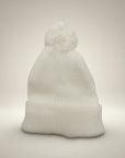 Stork And Baby white knit infant earflap hat with pom pom. Soft, cozy, and perfect for winter.